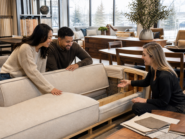 Homeowner examining the construction of a Canadian-made sofa in a Victoria showroom