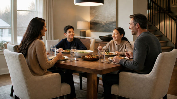 Family gathered for dinner on upholstered dining chairs in a warm, naturally lit Victoria home